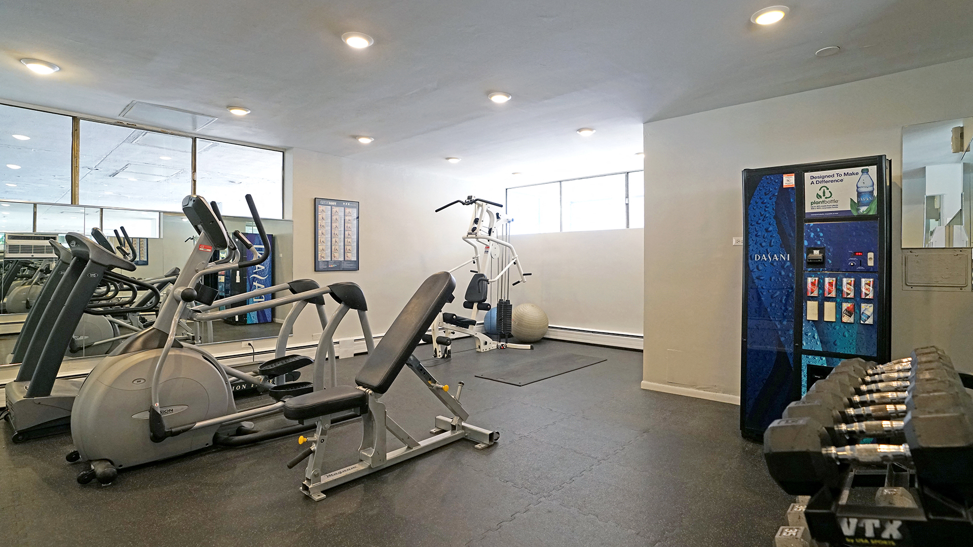 a gym with cardio equipment and a vending machine