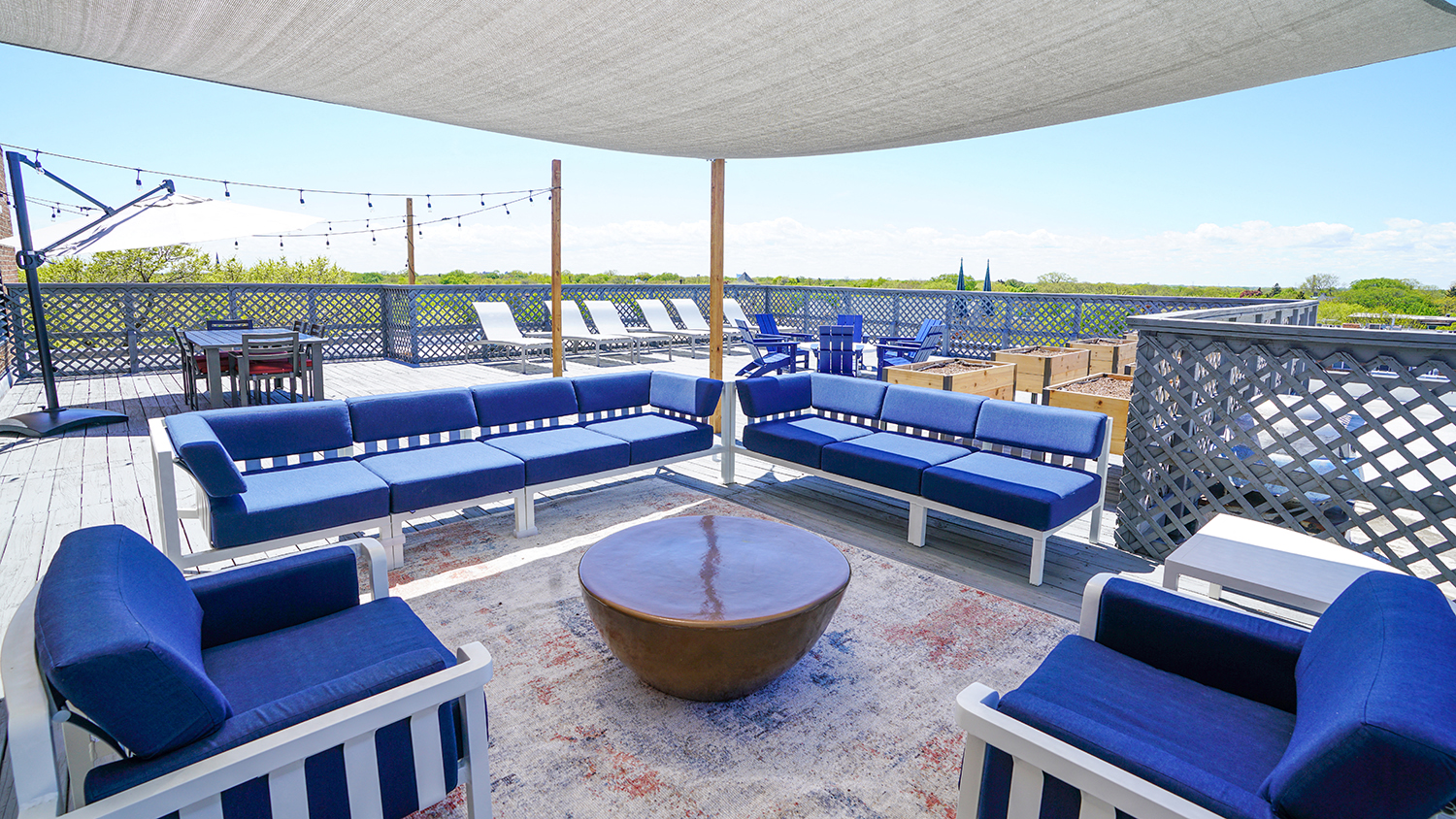 the deck on the top of the building has couches and a table