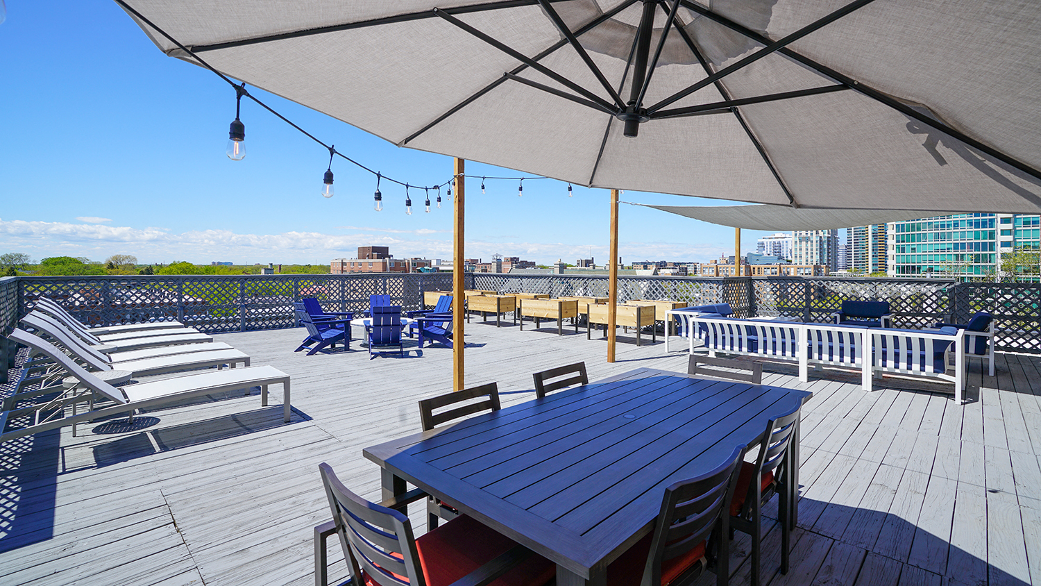 the deck on the top of the building has a table and chairs with an umbrella