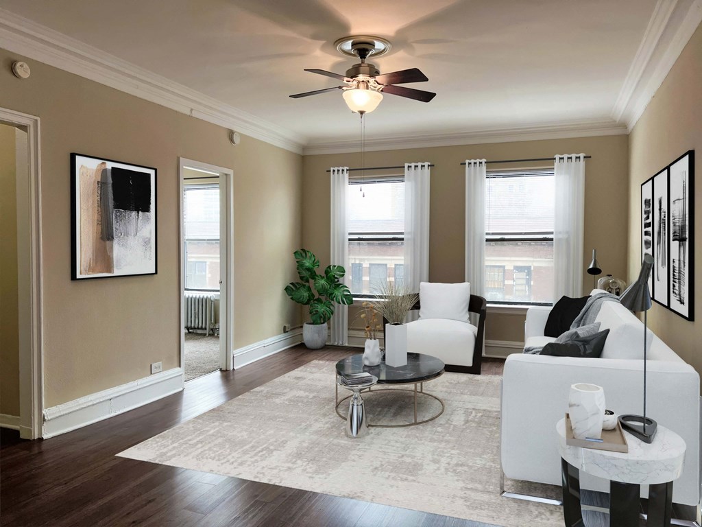 a living room with white furniture and a ceiling fan