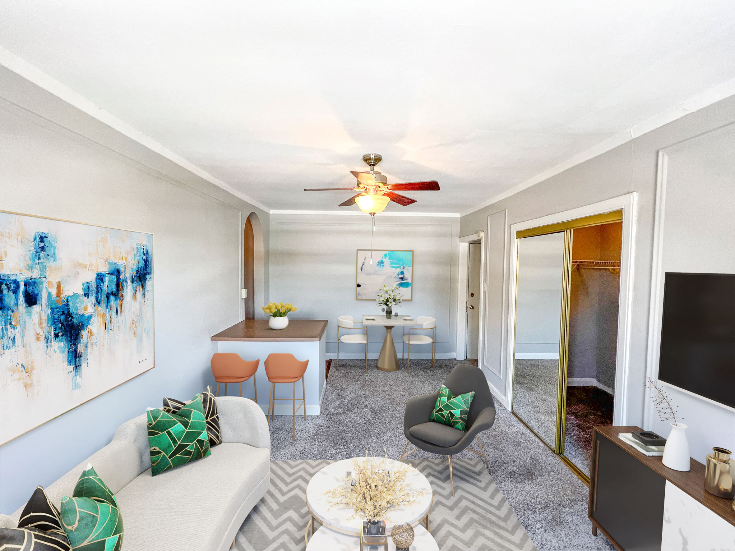 a living room with a couch and a table and a ceiling fan