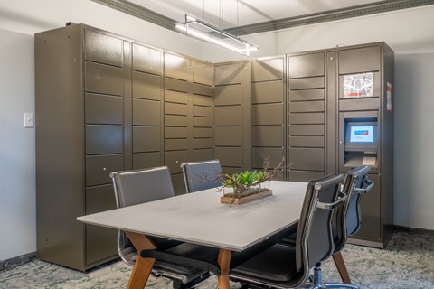 a conference room with a white table and chairs and stainless steel lockers