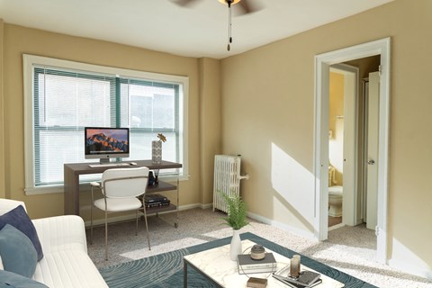 a living room with a couch and a desk with a computer