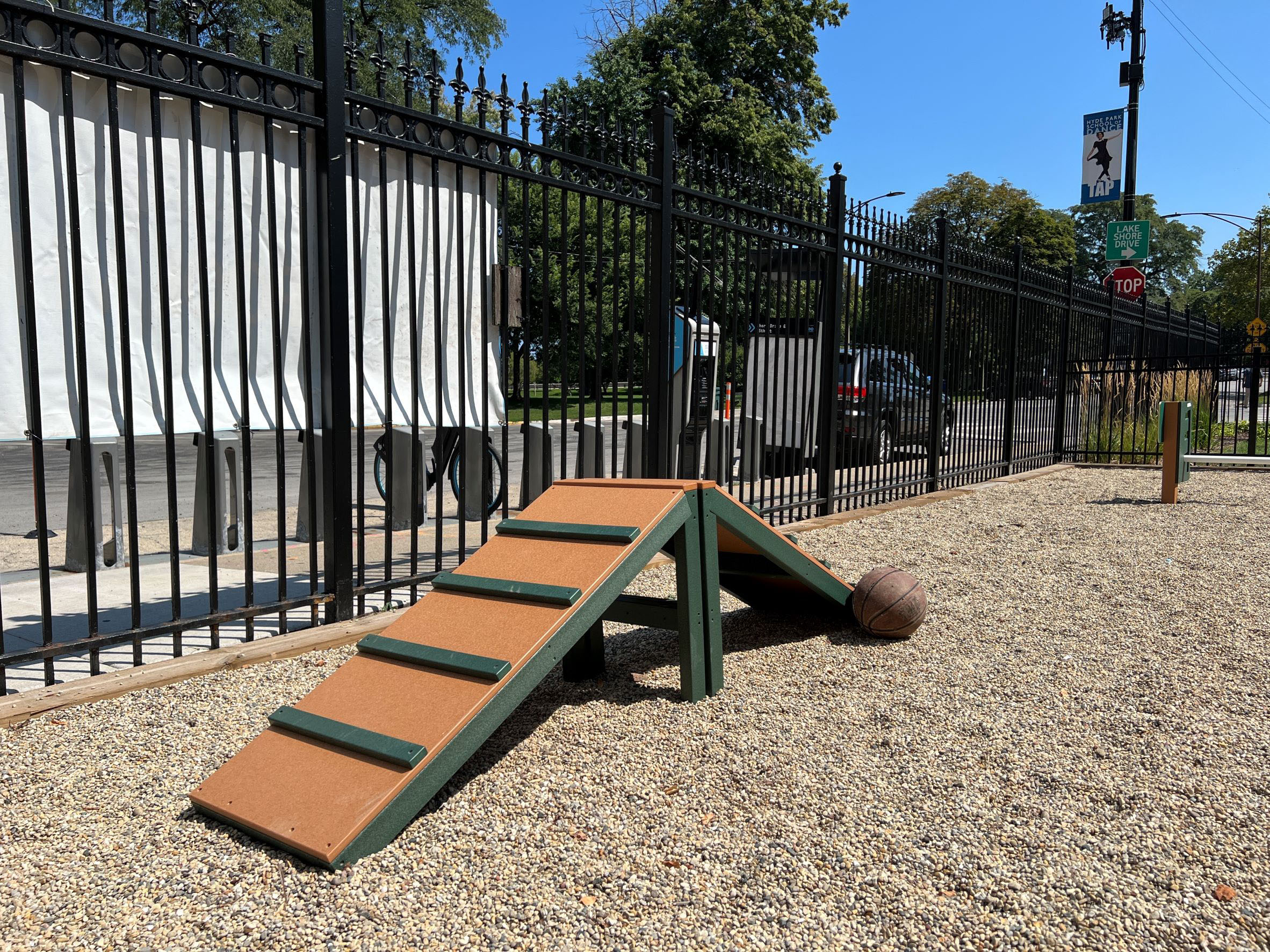 a picnic bench and a ball in front of a fence