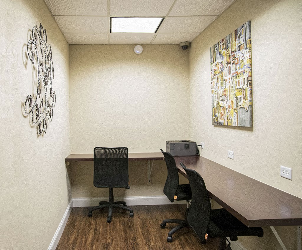 a conference room with a desk and chairs and a printer