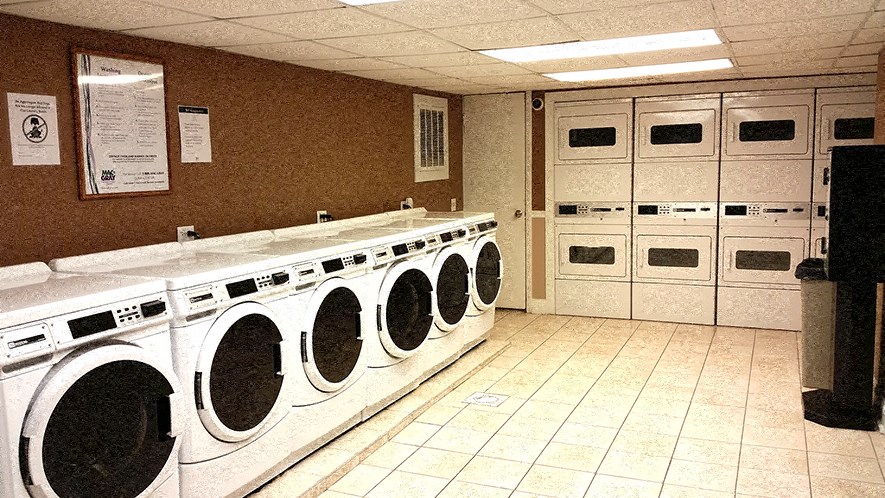 a laundry room with many washers and dryers in it