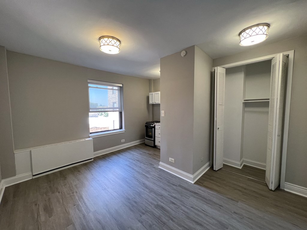 an empty living room with grey walls and a window