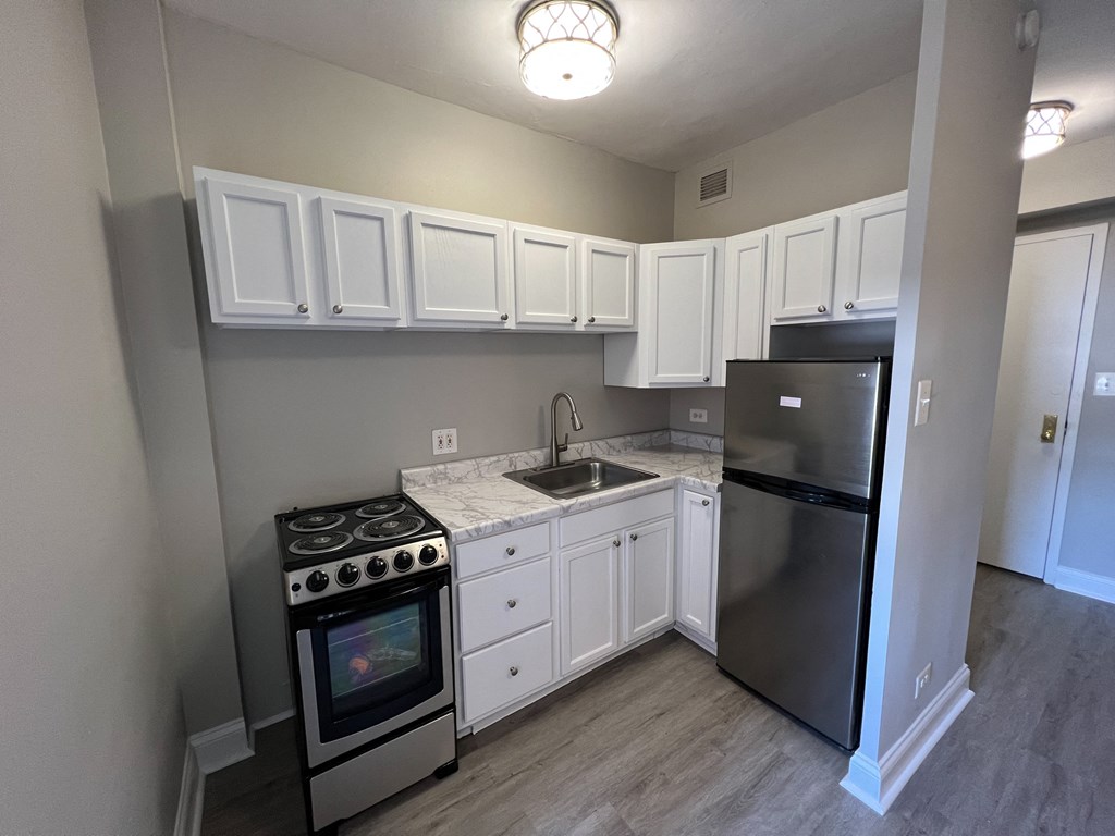 a kitchen with white cabinets and stainless steel appliances