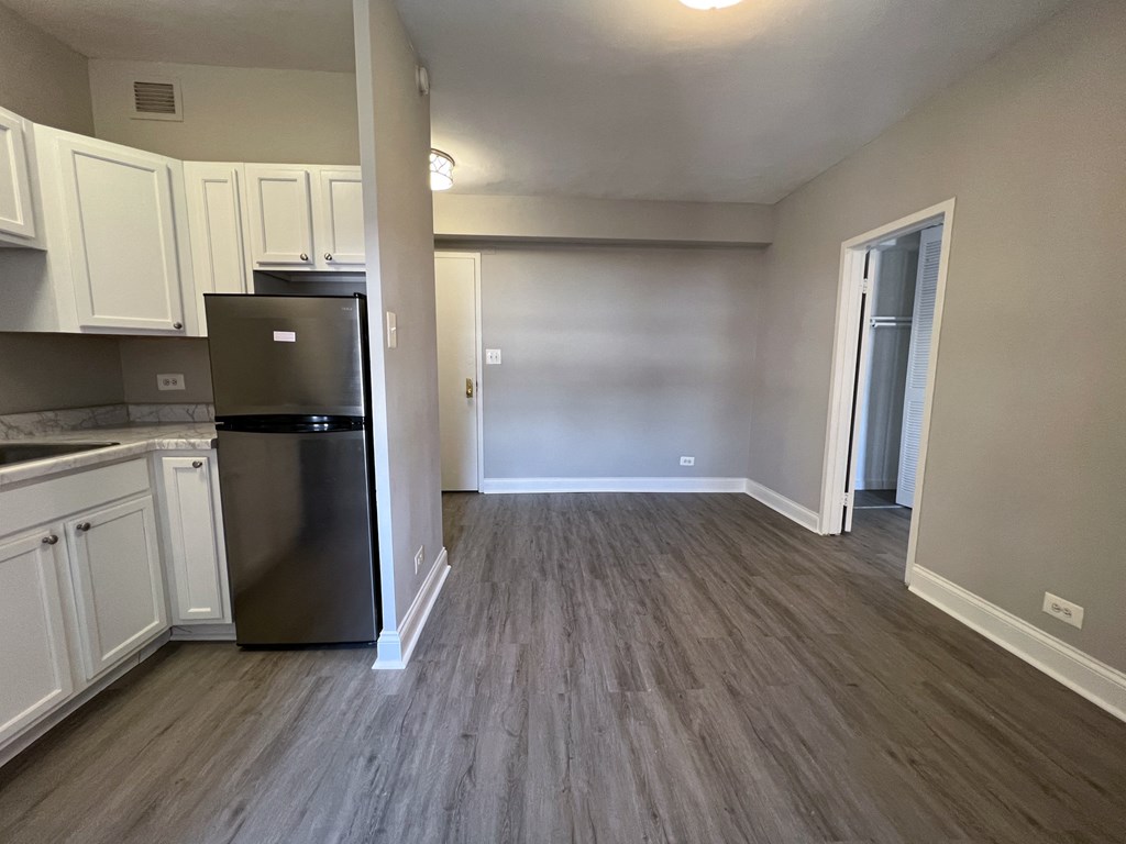 a kitchen with white cabinets and a stainless steel refrigerator