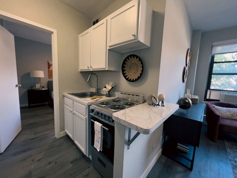 a kitchen with white cabinets and a sink and a stove