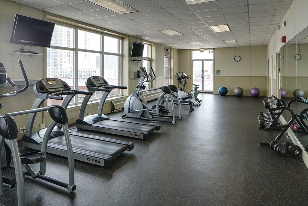 a gym with cardio equipment and weights in a building