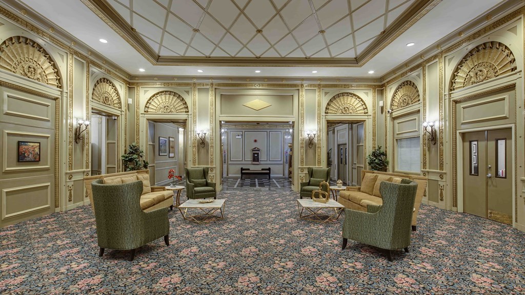 a lobby with couches and chairs and a large carpet