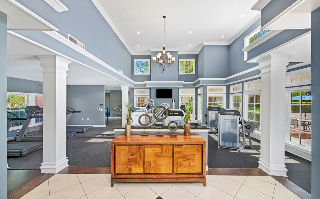 a gym with a desk and a bike in the middle of it