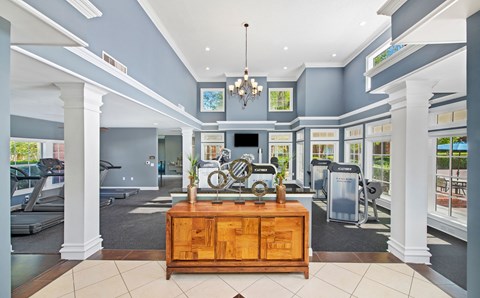 a gym with a desk and a bike in the middle of it