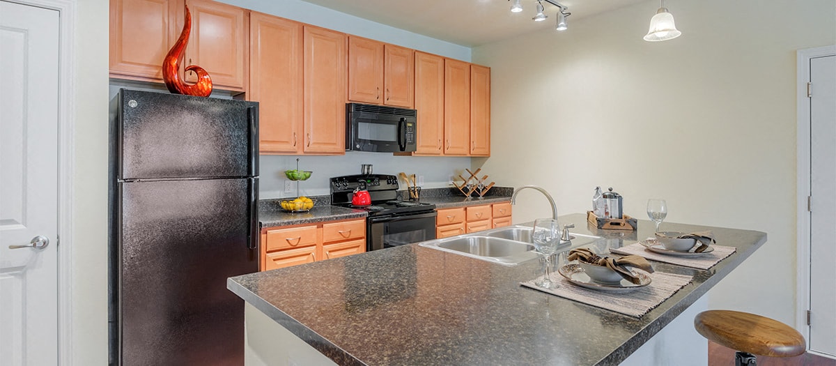 a kitchen with granite counter tops and a black refrigerator