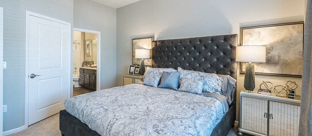 a bedroom with a bed and a door to a bathroom