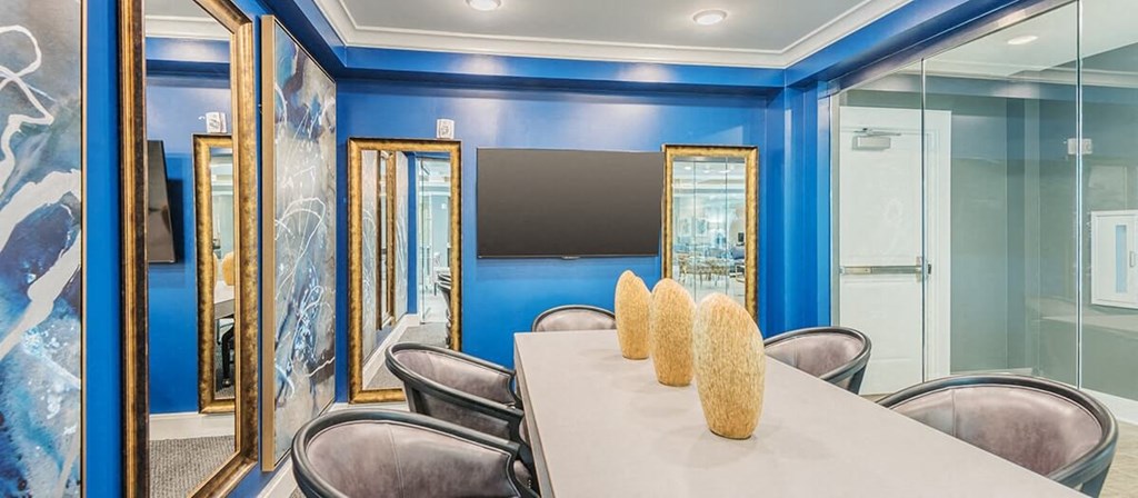 a conference room with a table and chairs and a television