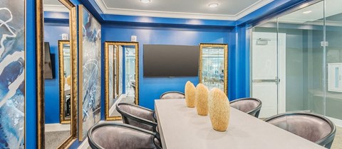 a conference room with a table and chairs and a television
