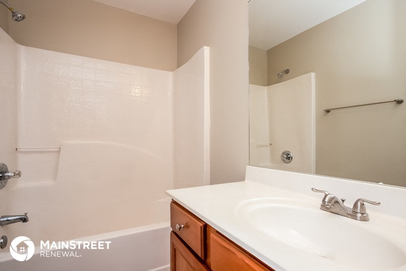a bathroom with a sink and a shower and a mirror