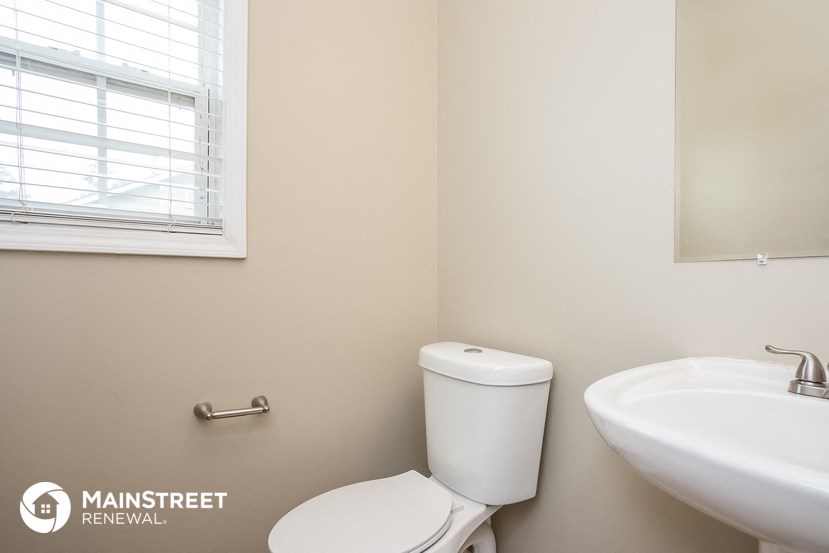 a bathroom with a toilet and a sink and a window