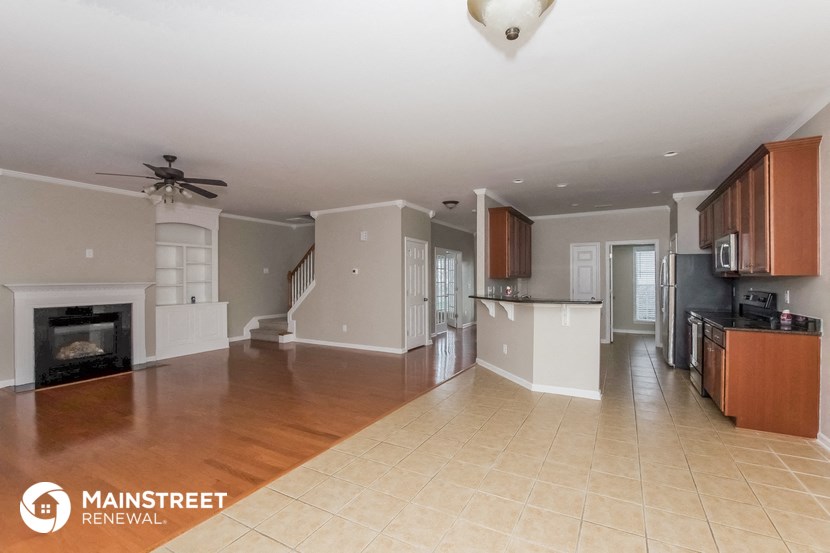 a large living room with a fireplace and a kitchen