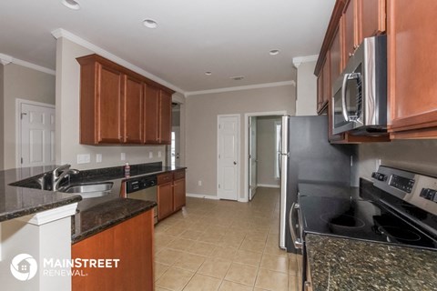 a kitchen with black granite counter tops and wooden cabinets