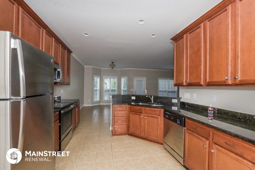 a large kitchen with wooden cabinets and stainless steel appliances