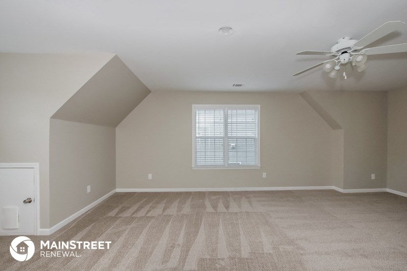 the spacious living room with vaulted ceilings and a ceiling fan