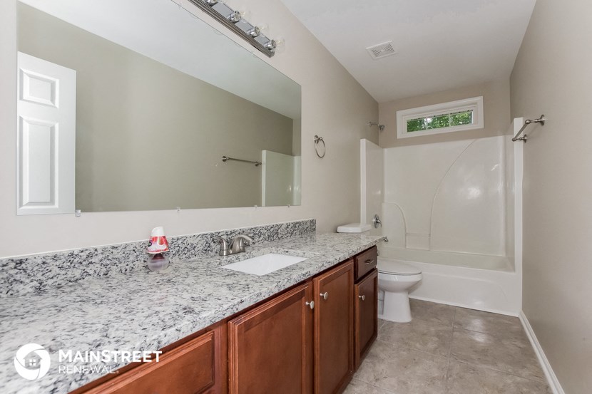 a bathroom with a large mirror and a sink and a toilet