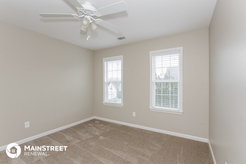 the master bedroom has a ceiling fan and carpeted flooring