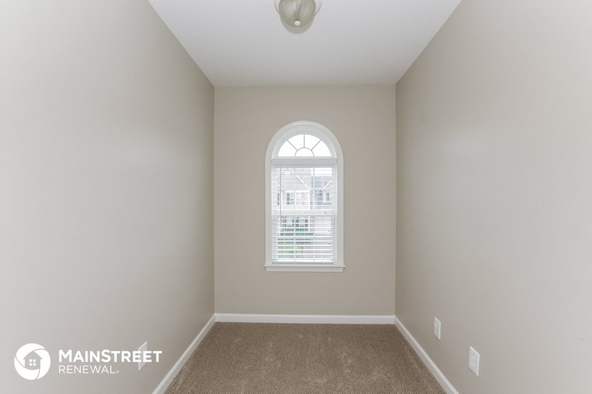 the master bedroom has a large window and carpeted flooring