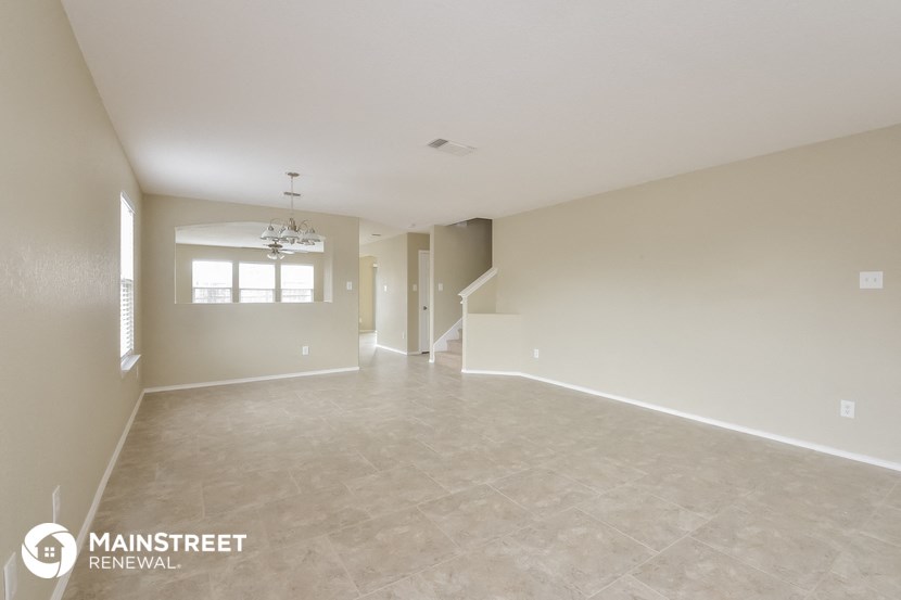 the spacious living room and dining room with the staircase to the second floor