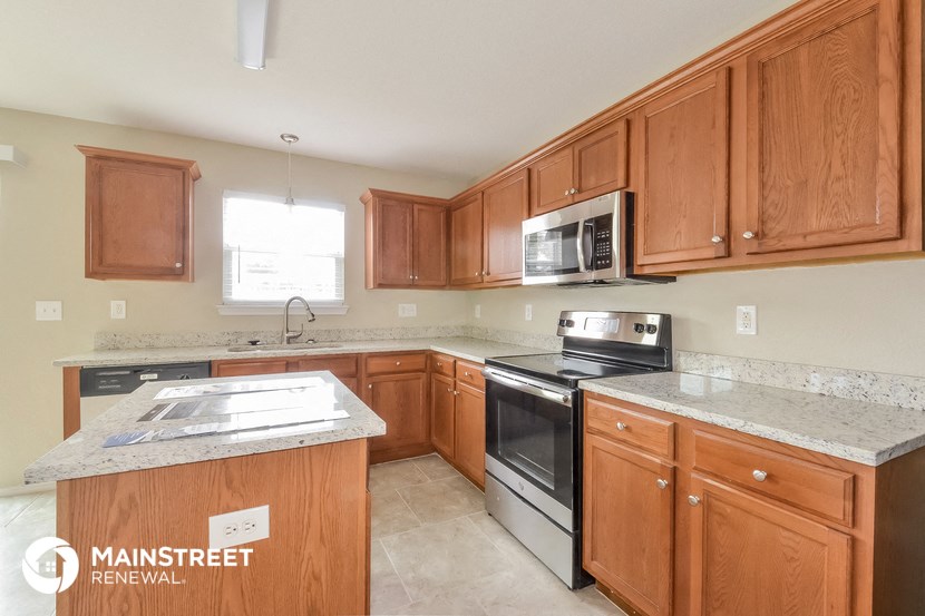 a kitchen with wooden cabinets and stainless steel appliances