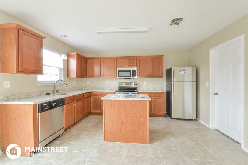a large kitchen with wooden cabinets and stainless steel appliances