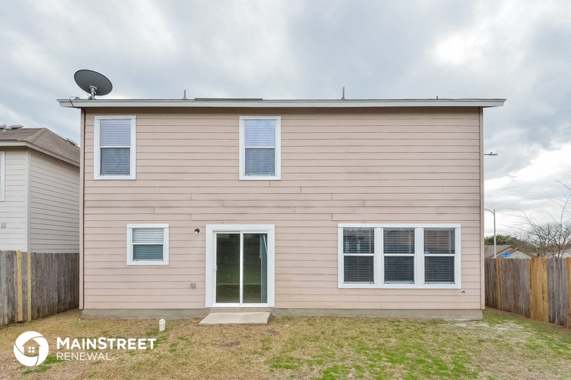 the exterior of a house with tan siding and white windows