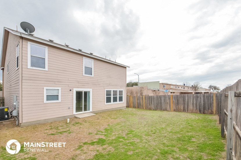 the backyard of a house with a yard and a fence