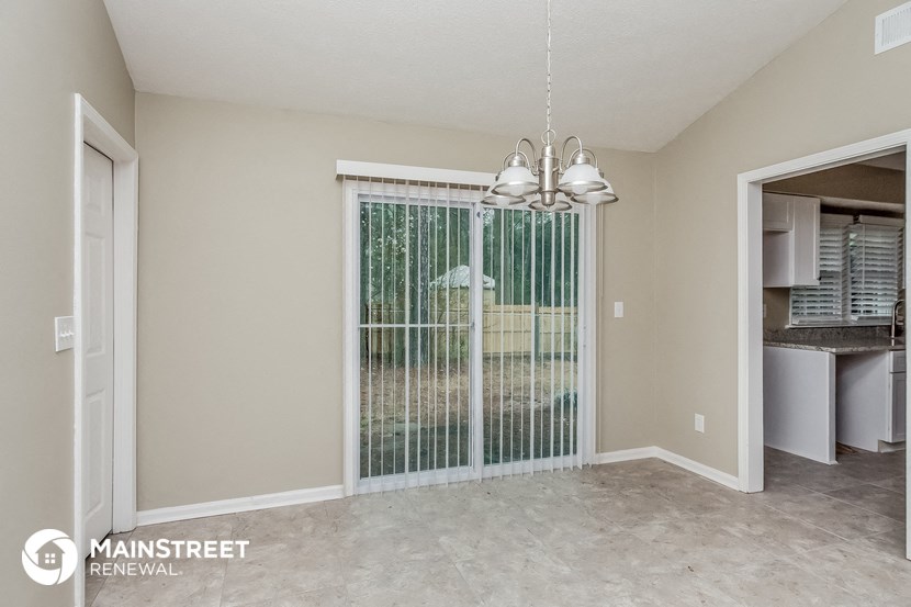 the living room and dining room of an apartment with a large window