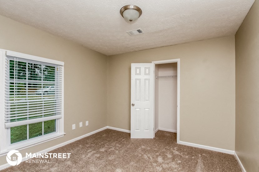 the master bedroom has a large window and a door to the closet