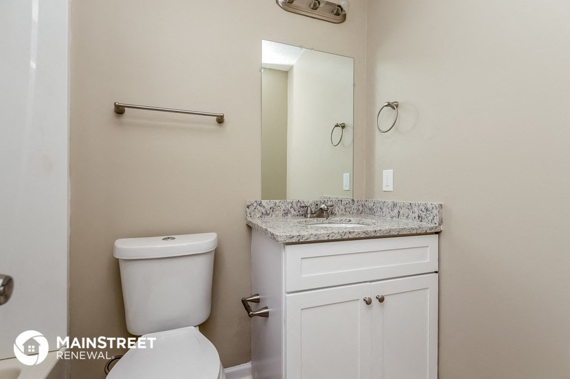 a bathroom with a toilet and a sink and a mirror