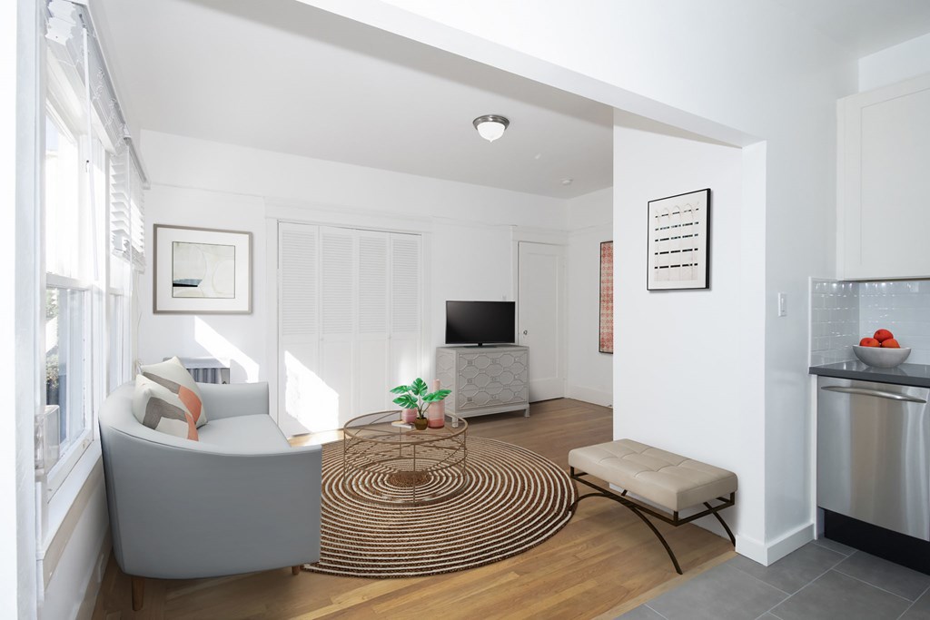 A modern living room with a grey sofa and a round woven coffee table.
