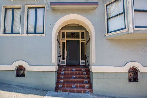 A building with a white door and steps leading up to it.