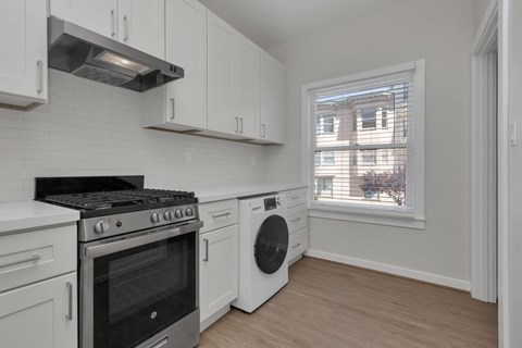 A kitchen with white cabinets and a black stove top oven.