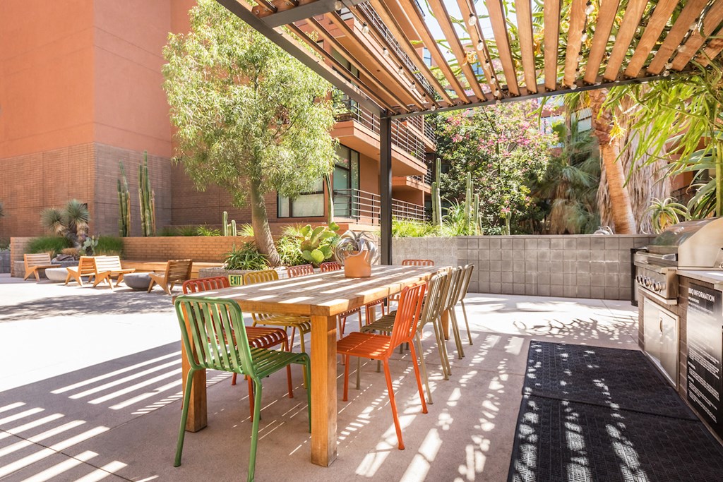 a dining area with a table and chairs under a wooden pergola
