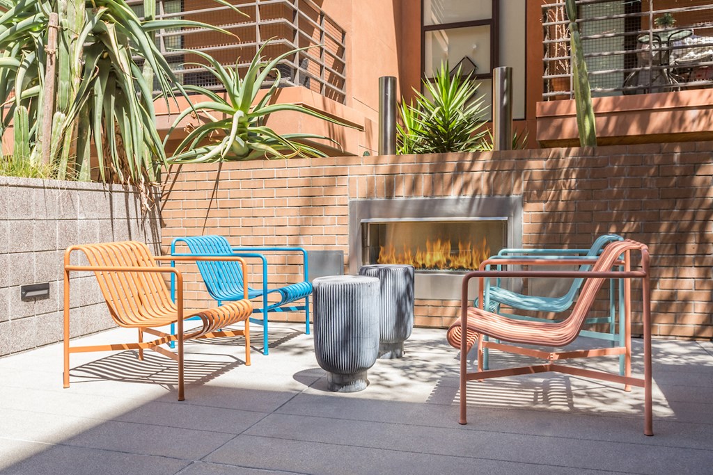 a patio with chairs and a fire pit