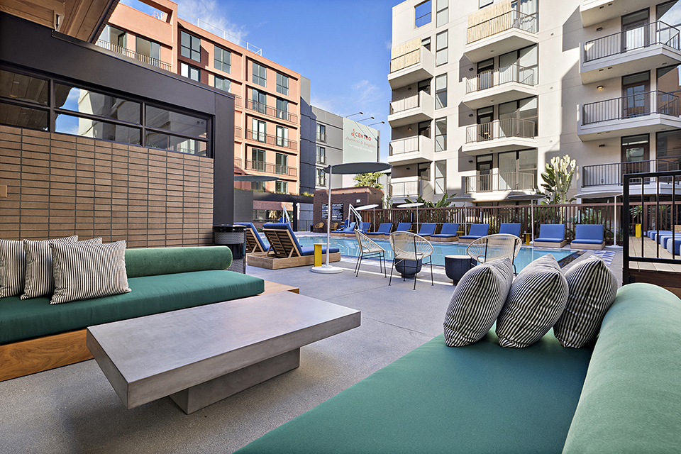 a communal area with couches and chairs and a pool at an apartment building