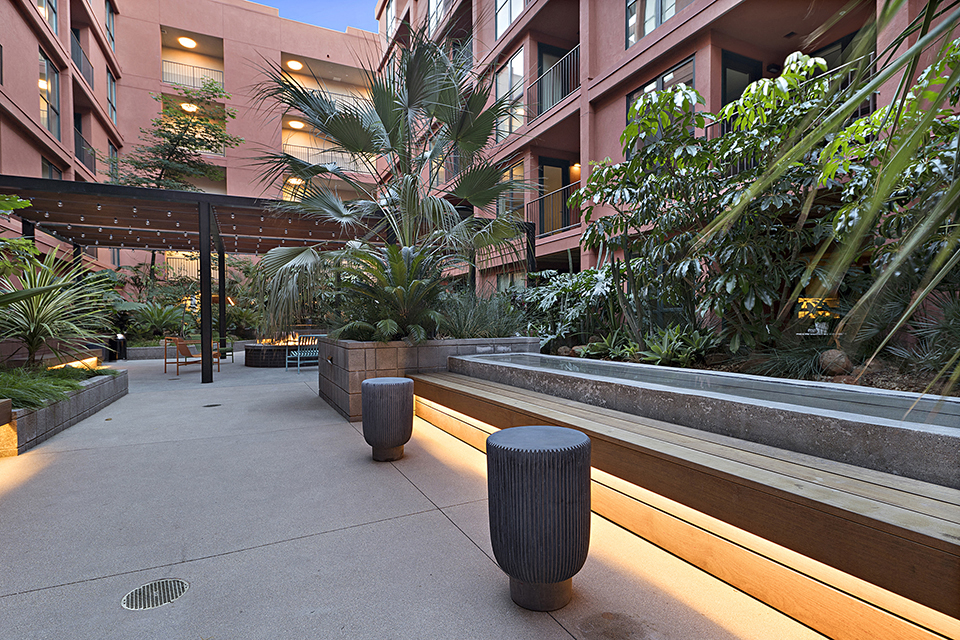 a courtyard with benches and plants at a hotel