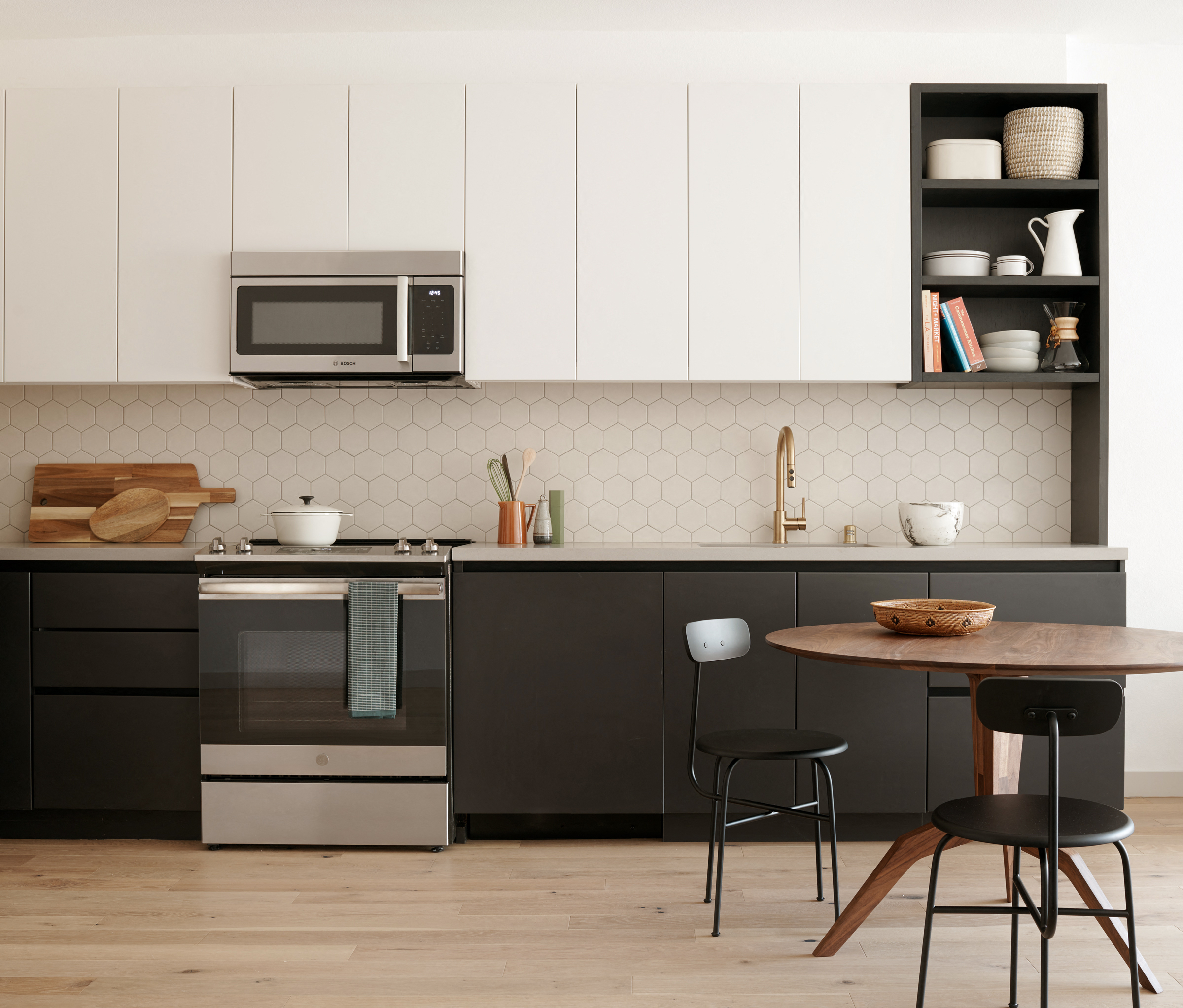 a kitchen with black and white cabinets and a table and chairs