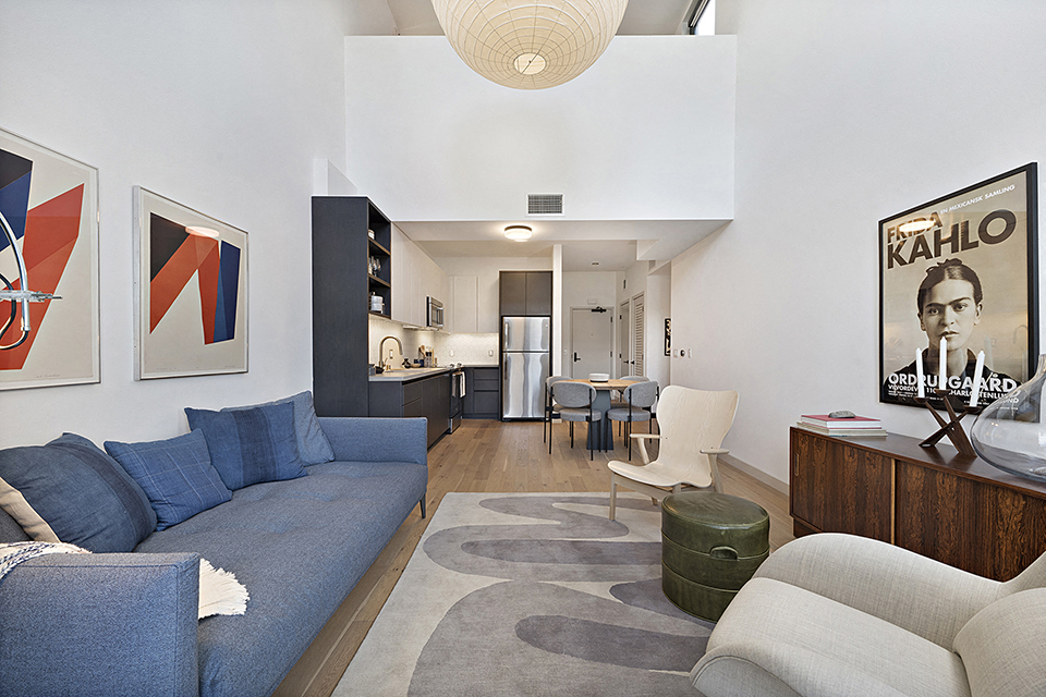 a living room with a blue couch and a rug