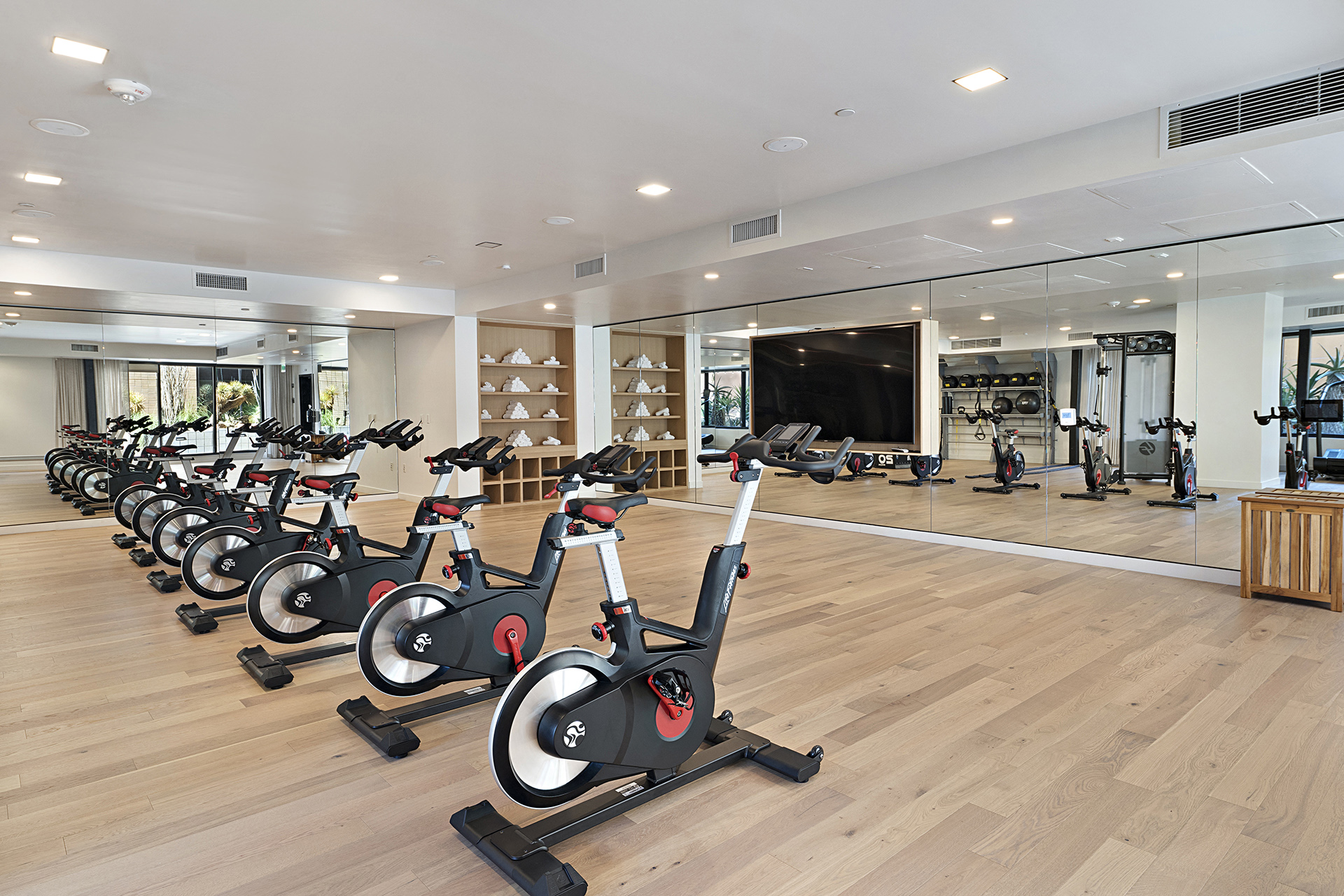 a slew of exercise bikes lined up in a room with a large number of exercise