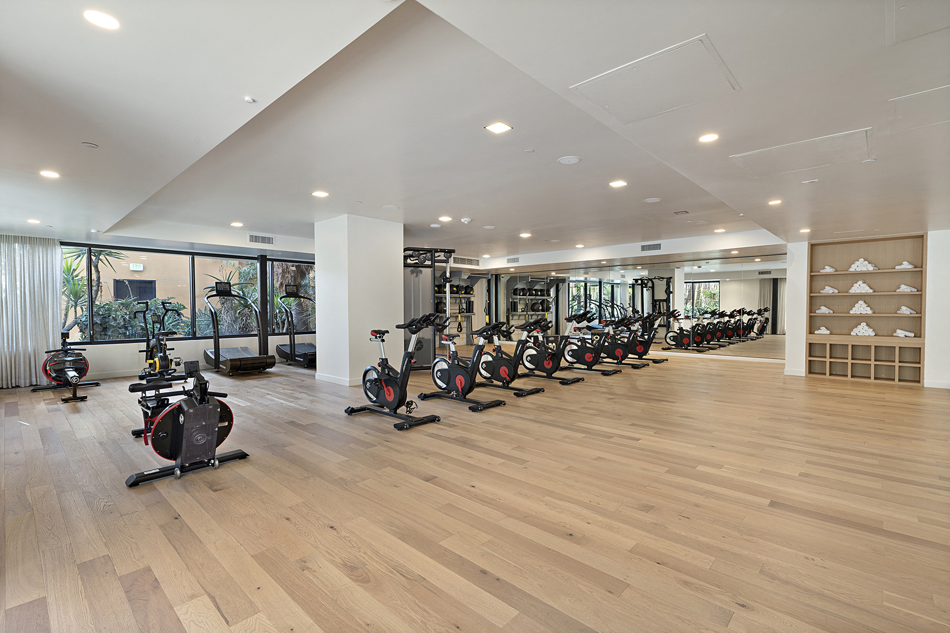 a gym with cardio bikes and weights on a wooden floor